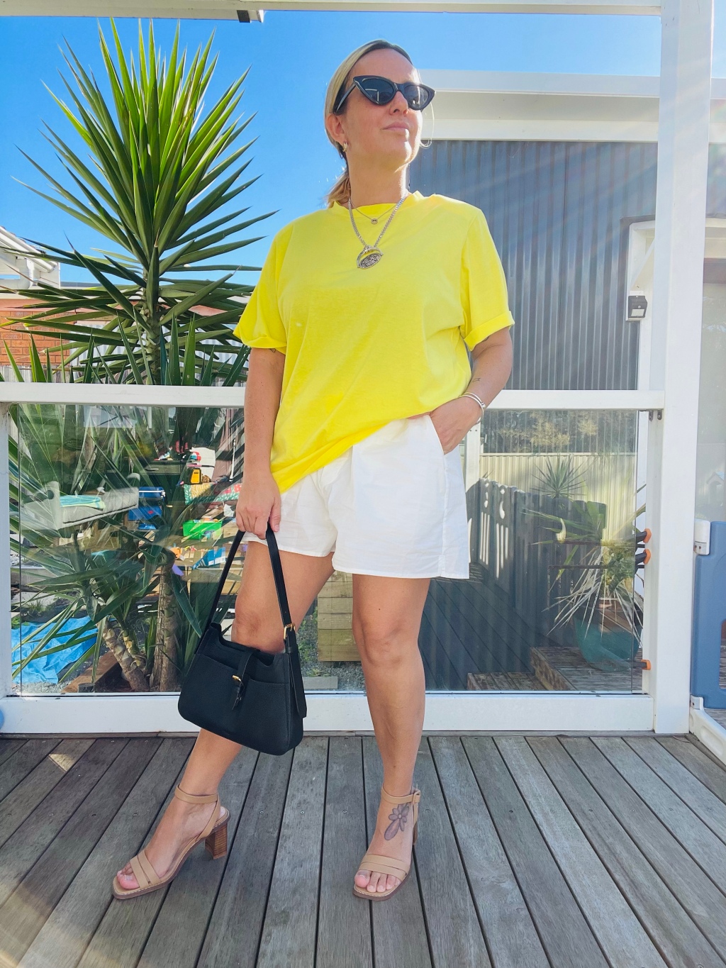 Summer outfit inspo: Bright yellow shirt and white cotton boxers style with tan heels